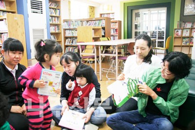 ▲ 배꽃작은도서관에서 아이들 책읽는 것을 도와주고 있는 책사랑봉사회원들
