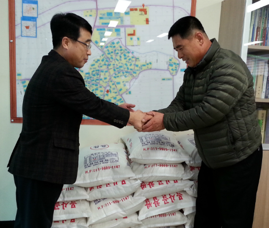 ▲ 이원근 농민회장(사진 오른쪽)이 곽삼성 산포면장에게 사랑의 쌀을 기탁하고 있다.